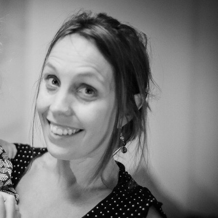 Svartvit bild på en person med uppsatt hår och prickig klänning.