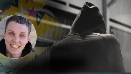 Person i svart hoodie står med ryggen mot kameran i en urban miljö med färgglad bakgrund.