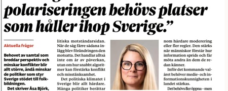 Flera personer skriver tillsammans på ett stort papper vid ett bord, fokus på händer och pennor.