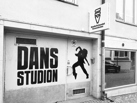 Ingång till en dansstudio med stor text 'DANS STUDION' och en siluett av en dansare på dörren.